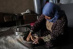 Debido a la escasez de harina, una mujer palestina recurrió a moler lentejas en masa para hacer pan.
