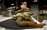 Officer Natalie Vorous unpacks boxes of geoduck at Sea-Tac searching for evidence they were harvested legally. These were not. They were confiscated.