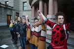 Arcadia Trueheart, Taylor Toro, and Molly Silverstein hold hands outside Portland City Hall. Protesters have called for Portland to be a sanctuary city for undocumented immigrants. 