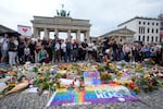 People gather outside the Brandenburg Gate for a demonstration in support of LGBTQ+ after a car rammed into a crowd at the Pride March in Berlin, Sunday, July 26, 2026. (AP Photo/Markus Schreiber)