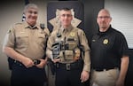 FILE - Klamath County Sheriff Chris Kaber, left, poses with his son, Ryan Kaber, center, during an award ceremony on Dec.  15, 2022, where Ryan, who bore a detective sergeant title, received the Oregon Law Enforcement Council’s Supervisor of the Year for the State of Oregon award.