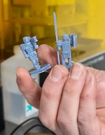Members of the group can use 3D printing to make custom game pieces like these two figurines.