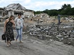 Local residents walk past a residential house, heavily damaged following a Russian missile strike on Sunday, in a village in the Brovary district, Kyiv region, amid the Russian invasion of Ukraine. Fragments of a missile fell on residential buildings in Brovary district, near Kyiv, the State Emergency Service of Ukraine said on Telegram.