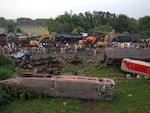 People watch at the site where trains that derailed, in Balasore district, in the eastern Indian state of Orissa, Sunday, June 4, 2023. Indian authorities end rescue work and begin clearing mangled wreckage of two passenger trains that derailed in eastern India, killing over 300 people and injuring hundreds in one of the country's deadliest rail crashes in decades.