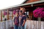 Maura Hammack, left, Albert Rollins and Kelli Jo Hammack stand in front of their house outside Madras, Oregon. John Hammack, the patriarch of the family, was killed in 2013 by a burning, falling tree.