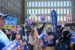Protesters hold signs in solidarity with the American Federation of Government Employees at a March 4 rally in support of federal workers at the Office of Personnel Management in Washington, D.C.