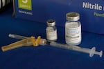 FILE - A syringe lies next to vials of COVID-19 booster vaccines at an inoculation station in Jackson, Miss., Friday, Nov. 18, 2022. (AP Photo/Rogelio V. Solis, File)