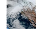 A satellite image shows clouds gathering above northern California and the Pacific Northwest.