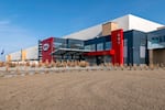 This photo shows the outside of DigiKey’s 2.2 million square-foot warehouse. The building has a long rectangular shape and has red accents near an entrance area.