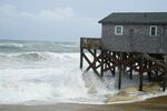Waves from Hurricane Erin crash against the sandbagged pilings of a building in Buxton, N.C., on Wednesday.