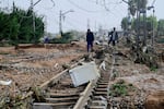 TOPSHOT - Residents walk among rubble on a railway track after flooding in Picanya, near Valencia, eastern Spain, October 30, 2024. Floods triggered by torrential rain in Spain's eastern Valencia region have killed 51 people, emergency services said on October 30. (Photo by Jose Jordan / AFP) (Photo by JOSE JORDAN/AFP via Getty Images)