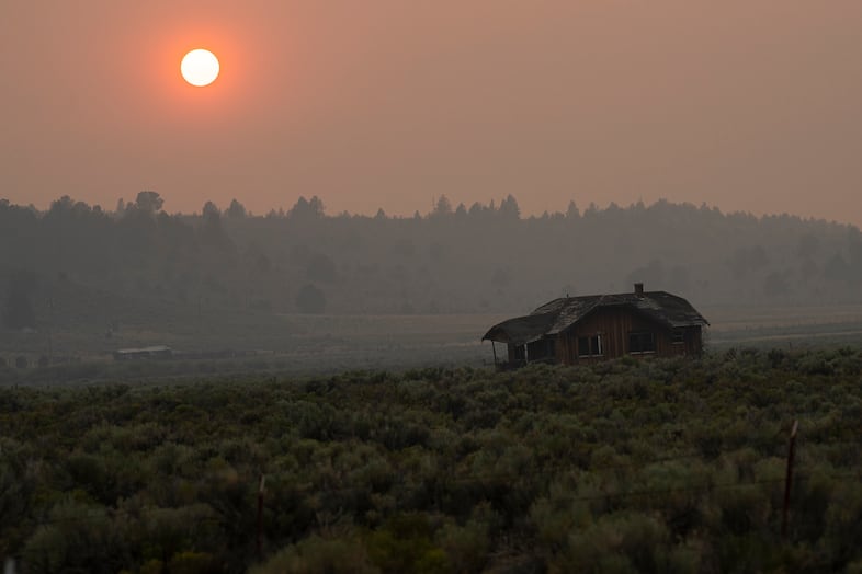 Hazy smoke-filled air in a rural area with a barn, fields and trees visible.