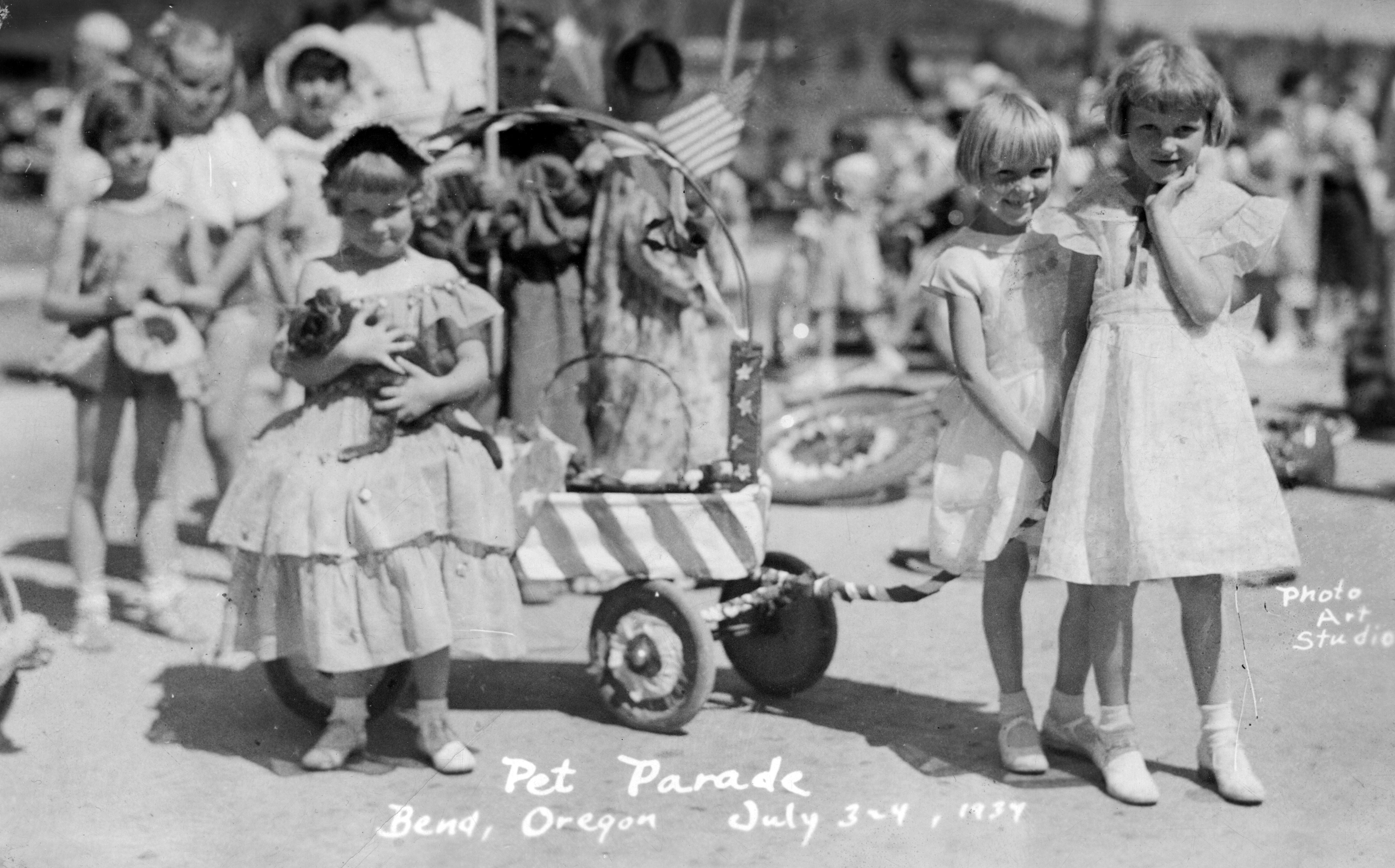 A group of young girls pose at the 1934 Bend pet parade. The girl on the left holds a cat.