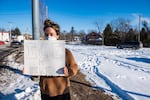 An activist stands outside across from what appears to be an U.S. Immigration and Customs Enforcement SUV in Portland, Maine on January 23, 2026.