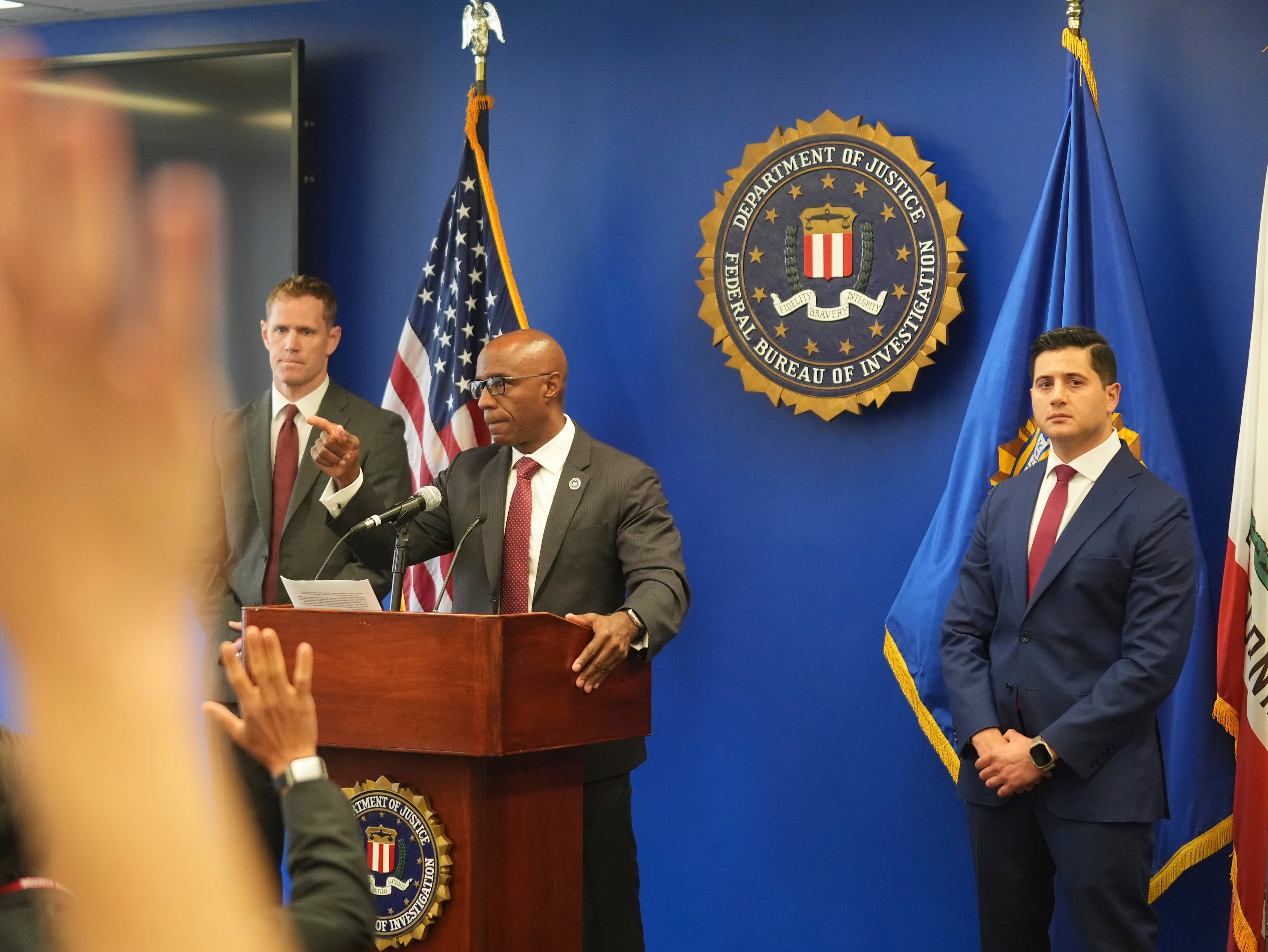 Akil Davis, Assistant Director in Charge of the FBI's Los Angeles Field Office, at podium, answers questions on the arrest of a Washington state man accused of providing chemicals used in last month's bombing during a news conference in Los Angeles, on Wednesday, June 4, 2025. At right, U.S. Attorney Bill Essayli.