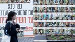 A woman passes by a wall covered with photos of hostages that were kidnaped to the Gaza Strip during Hamas deadly attack on January 6, 2025 in Kfar Saba, Israel.