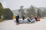 In this photo provided by the New South Wales Police, emergency workers wade through floodwaters as they prepare inflatable boats to effect rescues near Taree, Australia, Thursday, May 22, 2025. (NSW Police via AP)