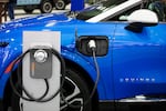 A Powering Michigan display about electric vehicles and charging is shown at the 2025 Detroit Auto Show on Jan. 10. The Biden administration promoted electric vehicles through a range of policies, which the Trump administration is in the process of reversing.