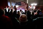 A woman holds up a small U.S. flag during a campaign rally by GOP presidential candidate and former President Donald Trump at the Rochester Opera House on Jan. 21 in Rochester, N.H.