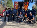 Portland firefighters pose with Tess, the Labrador, shortly after rescuing her from a manhole in Portland, Ore., on March 17, 2023.