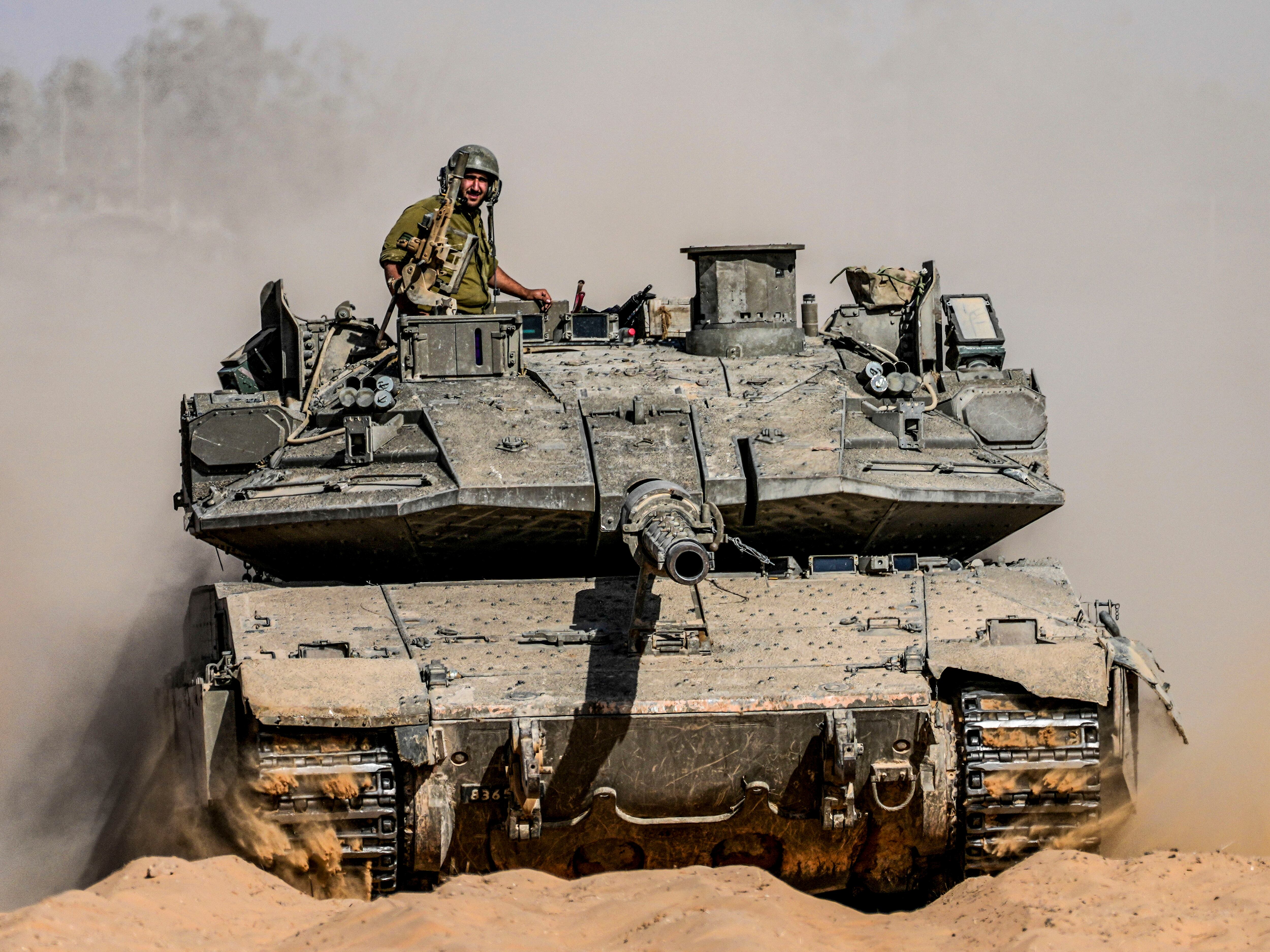 Israeli soldiers drive a tank at a staging ground near the border with the Gaza Strip, in southern Israel on Sunday.
