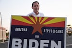 Dan Barker, a retired judge who created the group "Arizona Republicans Who Believe In Treating Others With Respect," poses with a sign to encourage voters to choose Democratic presidential candidate Joe Biden, during evening rush hour in Phoenix in October 2020.