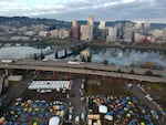 FILE - In this aerial photo taken with a drone, tents housing people experiencing homelessness are set up on a vacant parking lot in Portland, Ore., on Dec. 8, 2020. In Feb. 2022, the mayor of Portland, Oregon, banned camping on the sides of certain roadways, and officials are exploring other aggressive options to combat homelessness. 