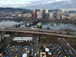 FILE - In this aerial photo taken with a drone, tents housing people experiencing homelessness are set up on a vacant parking lot in Portland, Ore., on Dec. 8, 2020. In Feb. 2022, the mayor of Portland, Oregon, banned camping on the sides of certain roadways, and officials are exploring other aggressive options to combat homelessness.