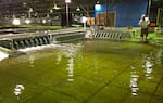 Sean Milligan with the U.S. Army Corps of Engineers throws confetti into the pool in the Little Goose Dam model, which is 55 times smaller than the real dam on the Snake River in Washington.