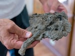 Bill Edge holds what remains of his motorcycle, May 26, 2023, found in the rubble of his former home in Gates, destroyed in the Santiam Canyon Fire in 2020. 