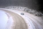 A car slowly navigates a snow-covered interstate Sunday, Jan. 5, 2025, in St. Louis.