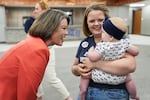 U.S. Rep. Angie Craig, D-Minn., candidate for U.S Senate, greets Merci Wolff and her daughter during a canvassing event at SMART Sheet Metal Workers Local #10 headquarters, Monday, Aug. 10, 2026, in St. Paul, Minn.