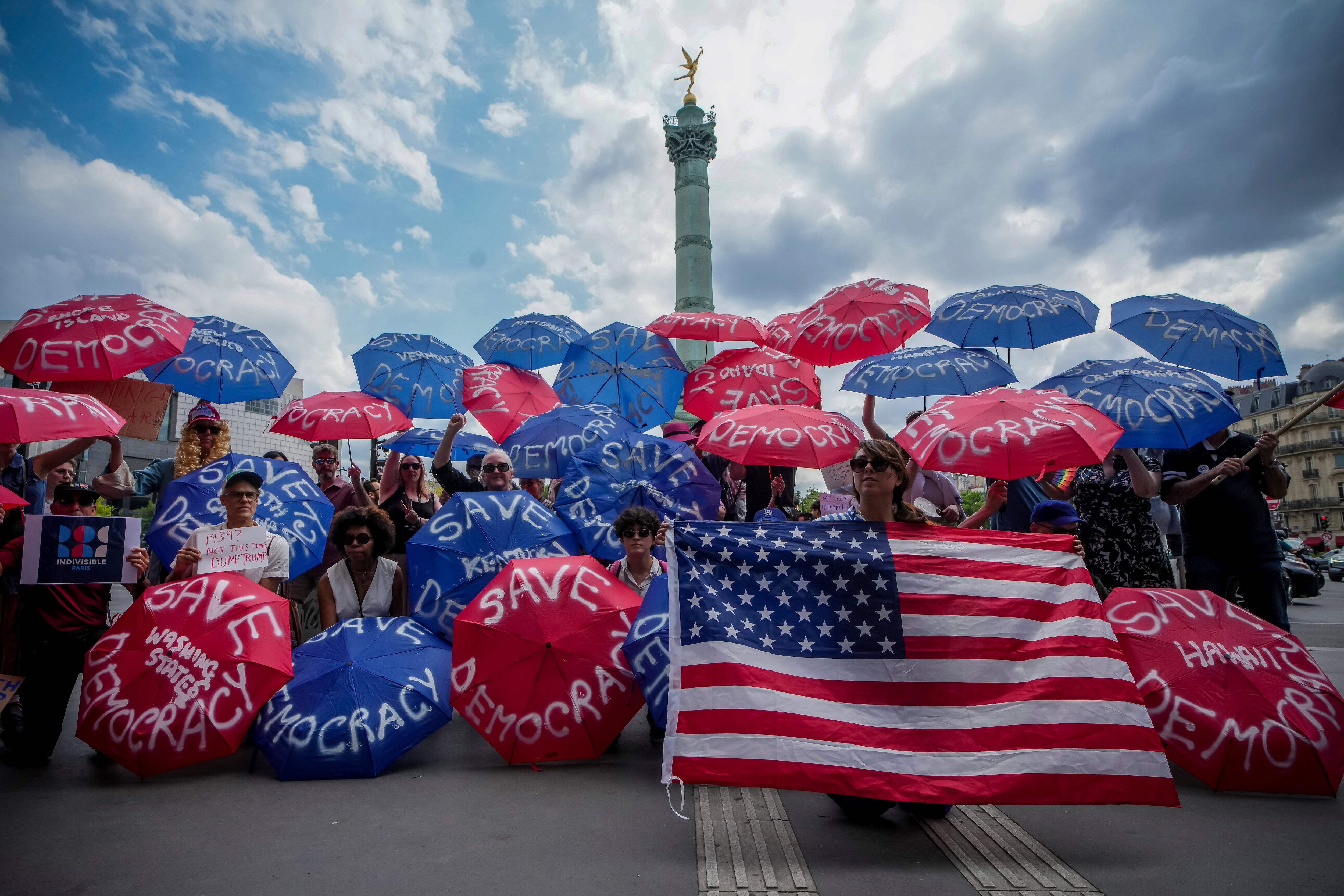 Paris, France: People holding umbrellas reading save democracy take part in the No Kings protest.