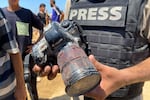 A journalist holds the blood-covered camera belonging to Palestinian photojournalist Mariam Dagga, who freelanced for The Associated Press and was killed in an Israeli strike on Nasser Hospital in Khan Younis, in the southern Gaza Strip, Monday.