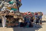 Afghan refugees sit next to their belongings loaded onto vehicles as they wait for opening of the border crossing point, which closed following Afghan and Pakistani security forces exchanged cross border firing, at a camp in Chaman, Pakistan, Sunday, Oct. 12, 2025.