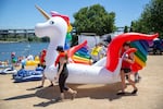 A rainbow unicorn float is carried down to the Willamette River by a group of people participating in the Big Float. 