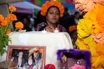 Celina Anaya lights electric candles and places them on the community ofrenda at the Día de Muertos celebration in Bend, Ore., on Nov. 7, 2025.