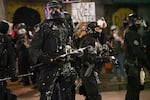 Paint covers Portland officers policing protests in downtown Portland, Ore., Aug. 12, 2020.