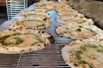 Par-baked pizzas cooling on a wire rack in Renata restaurant in Southeast Portland. The pizzas will be packaged and frozen for resale in local grocery stores.