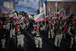 Members of the Bolivarian militia, wearing uniforms and carrying firearms, stand in rows and wave Venezuelan flags as they participate in a military deployment in support of Venezuelan President Nicolás Maduro in Caracas, Venezuela, on September 23.
