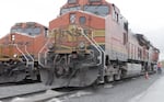 A single worker walks next to a BNSF locomotive. BNSF and a committee of the SMART labor union have reached a tentative agreement to allow one-man crews on trains as early as next year. Many railroad workers think 