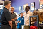 David Crowley, right, Democratic candidate for Wisconsin governor talks with CJ Arthur, left, owner of WordHaven BookHouse during a campaign stop with Wisconsin Gov. Tony Ever, center, Friday, Aug. 7, 2026, in Sheboygan, Wis.