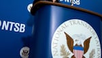FILE - The National Transportation Safety Board logo and signage are seen at a news conference at NTSB headquarters in Washington, Dec. 18, 2017.