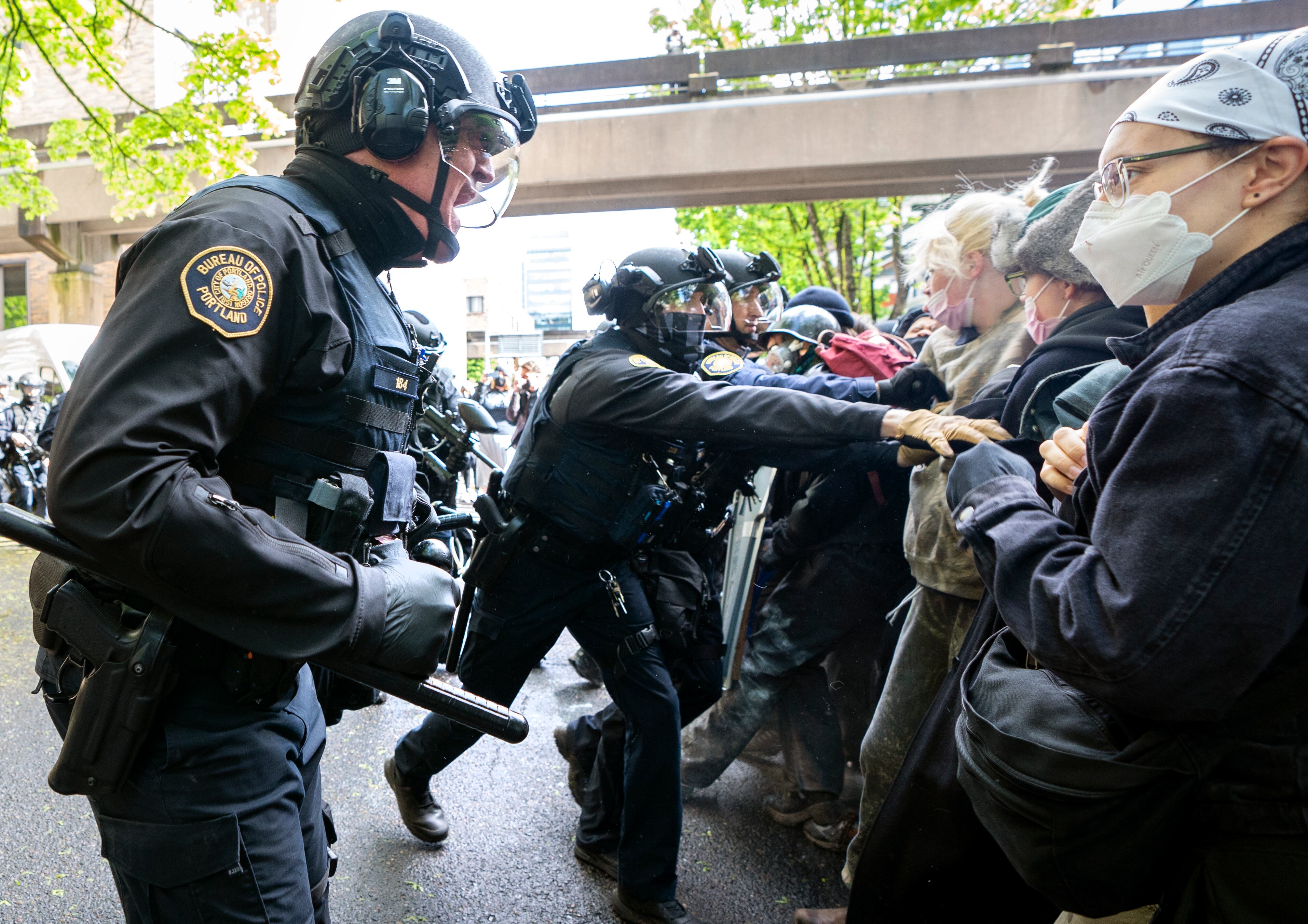 Police confront protesters attempting to stop a white van carrying protesters detained by police at Portland State University's Branford Price Millar Library, May 2, 2024. People protesting Israel's role in the war in Gaza had occupied the library since Monday evening.