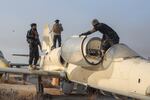 Syrian opposition fighters stand on a military plane Monday at the Al-Nayrab military airport outside the northwestern city of Aleppo. The rebels captured the city and surrounding areas in recent days. The Syrian military is now trying to regroup.