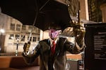 The Umbrella Man statue wears a mask in Pioneer Courthouse Square in Portland, Ore., Saturday, April 18, 2020. Some public health officials have encouraged people to wear masks to slow the spread of COVID-19.