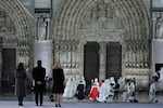 Mayor of Paris Anne Hidalgo (L), French President Emmanuel Macron (2L) and his wife Brigitte Macron (3R) stand as the Archbishop of Paris, Laurent Ulrich (C), walks to the doors of Notre-Dame Cathedral during a ceremony to mark the re-opening of the landmark Cathedral, in central Paris, on December 7, 2024. Around 50 heads of state and government are expected in the French capital to attend the ceremony marking the rebuilding of the Gothic masterpiece five years after the 2019 fire which ravaged the world heritage landmark and toppled its spire. Some 250 companies and hundreds of experts were part of the five-year restoration project at a cost of hundreds of millions of euros. (Photo by Christophe PETIT TESSON / POOL / AFP) (Photo by CHRISTOPHE PETIT TESSON/POOL/AFP via Getty Images)