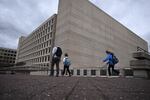 People walk past the U.S. Department of Energy building in Washington, D.C.