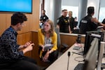Portland City Council Clerk Keelan Whetstone, center, talks with Eben Joondeph Hoffer, left, as security staff and attendees begin entering before the City Council meeting at Portland City Hall in Portland, Ore., on July 8, 2026.