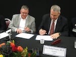 OHSU President Joe Robertson and Adventist's chief Bill Wing sign a deal to affiliate.